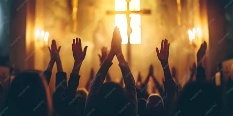 Iglesia llena de gente con las manos levantadas en adoración durante un concierto de música cristiana