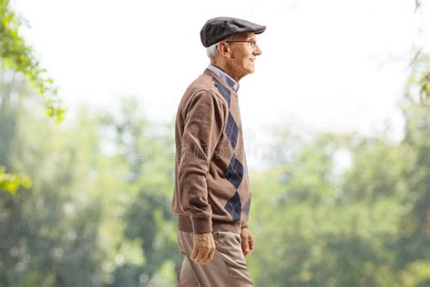 Hombre mayor caminando en un parque soleado