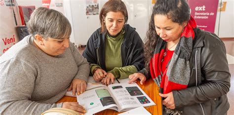 Fotografía de un grupo de adultos mayores participando activamente en un taller de alfabetización digital.