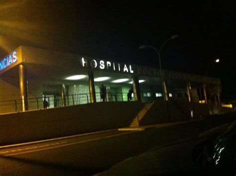 Foto de fachada de hospital de noche con ambulancia