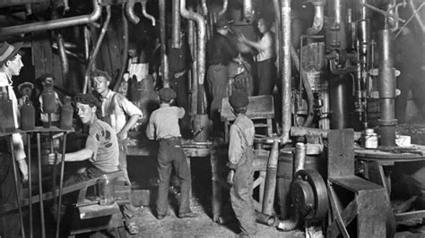 Fotografía histórica de obreros en una fábrica española del siglo XIX, ilustrando las condiciones laborales.