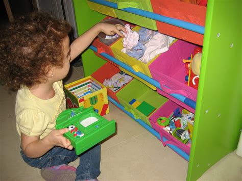 Imagen de una niñera organizando juguetes en una habitación de niños