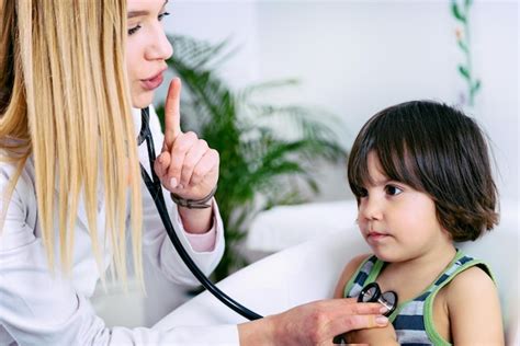 Pediatra examinando a un niño en su hogar