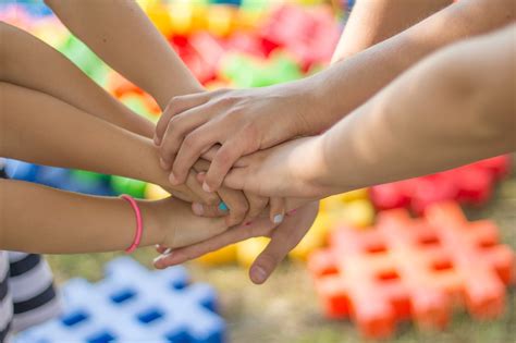 Foto temática: Manos de niños entrelazadas con las de un adulto, simbolizando protección y reunificación familiar