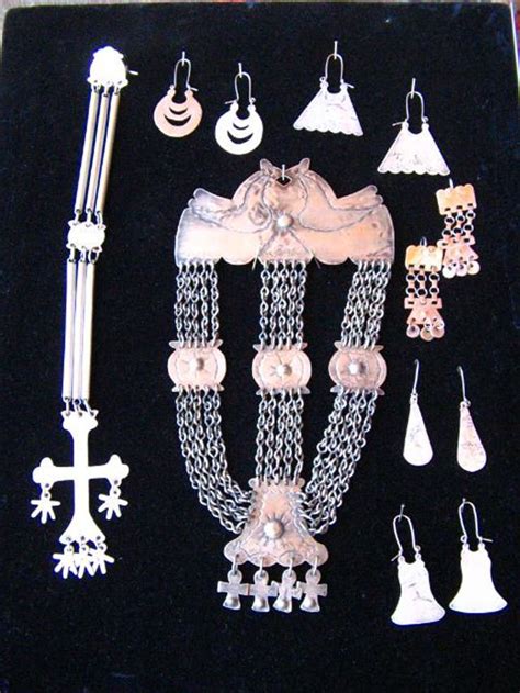 Varias joyas de plata mapuche y textiles con diseños tradicionales en una exposición.