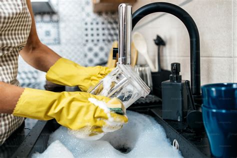 Foto temática de una mujer mayor trabajando en una cocina de restaurante, lavando platos