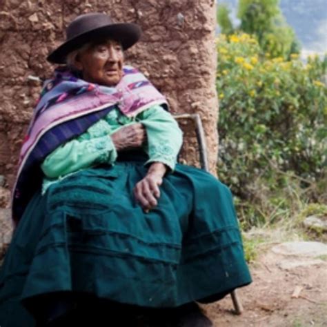 Filomena Taipe Mendoza, mujer andina, sentada con su bastón
