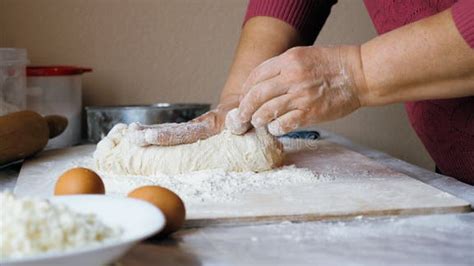 Mujeres mayores italianas amasando pasta a mano en una cocina rural