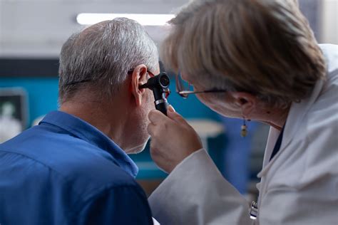 Profesional médico realizando un examen del oído con otoscopio
