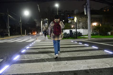 Ilustración de una persona mayor usando la Tarjeta Cruce Seguro en un cruce peatonal