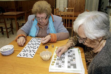 Foto de personas mayores jugando al bingo musical con cartones coloridos