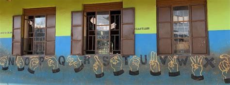 El alfabeto en lenguaje de signos pintado en la pared de una escuela de Uganda.
