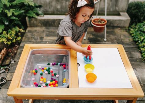 Niño explorando texturas y luces en una mesa sensorial adaptada