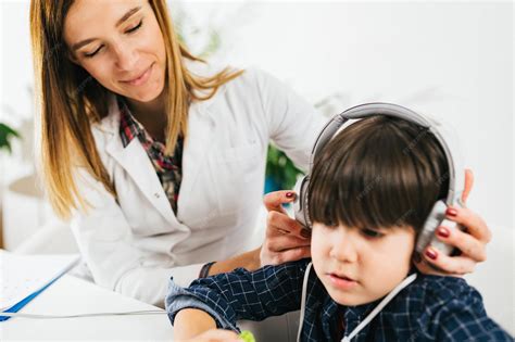 Foto de un niño realizando una prueba de audición con auriculares en una cabina insonorizada