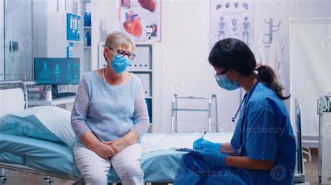 Profesional de enfermería interactuando con un paciente mayor, explicando su medicación