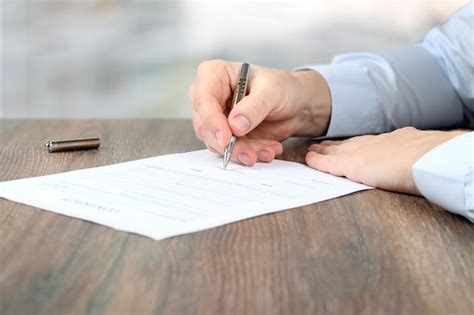 Persona firmando documentos con un asesor para solicitud de pensión de invalidez