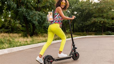 Fotografía de una persona utilizando un patinete eléctrico en una vía urbana, con atención a la seguridad.