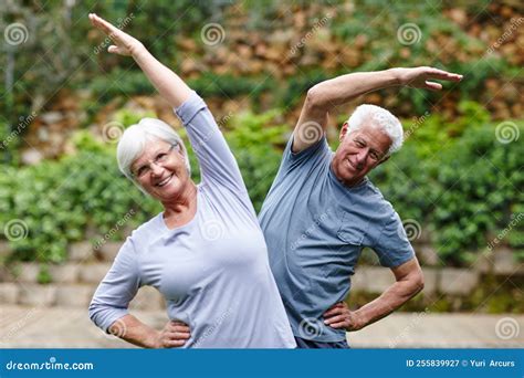 Foto temática de adultos mayores activos y sonrientes al aire libre, realizando una caminata o estiramientos.