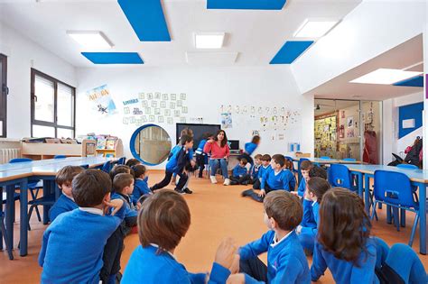 Imagen de un aula escolar adaptada con mobiliario regulable en altura y espacios amplios para sillas de ruedas.