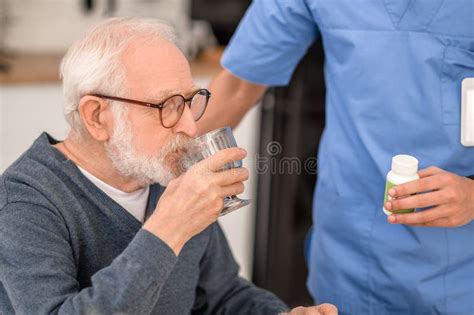 Persona mayor tomando medicamentos con ayuda de tecnología