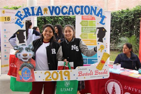 Estudiantes participando en una feria vocacional con stands informativos