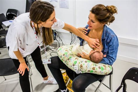 Foto de matrona educando a una madre sobre lactancia materna en un ambiente tranquilo de hospital