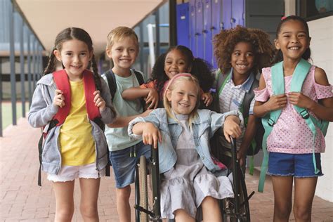 Fotografía de un grupo de niños con diversas discapacidades interactuando en un entorno inclusivo