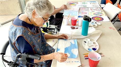Adultos mayores participando en un taller de pintura o manualidades