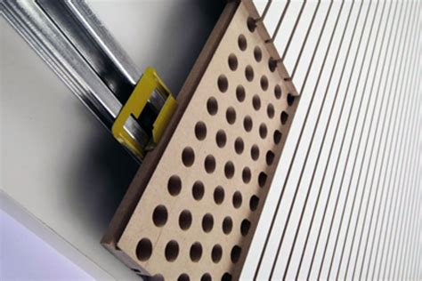 Esquema técnico sobre la disposición de materiales fonoabsorbentes en aulas o espacios públicos.