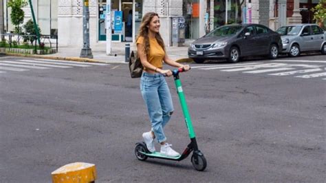 Persona utilizando un scooter eléctrico en un entorno urbano