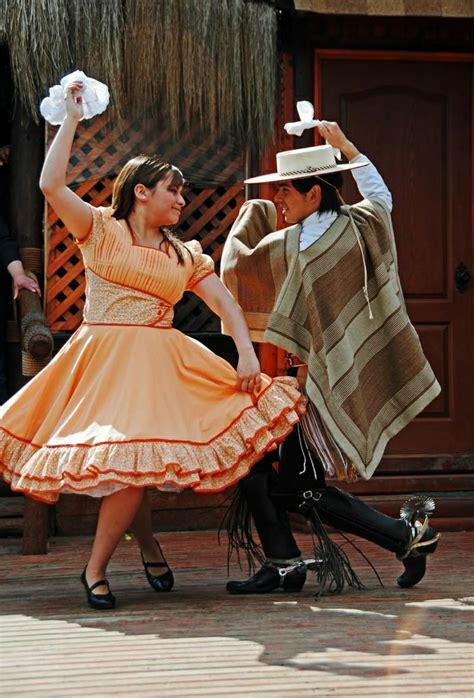 Pareja de adultos mayores bailando cueca con trajes típicos chilenos