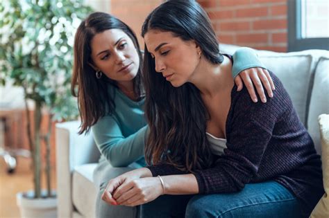 Foto temática: Familia consolándose mutuamente en un momento de duelo, simbolizando apoyo.