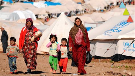 Fotografía antigua de un campo de refugiados o de la posguerra, con dos personas mirándose con esperanza.