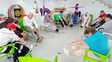 Fotografía de un entorno residencial especializado para el cuidado de adultos mayores con Alzheimer, mostrando interacción con cuidadores