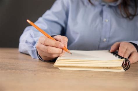persona mayor escribiendo en un cuaderno con una expresión pensativa