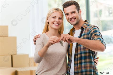 Fotografía de personas sonriendo y recibiendo las llaves de su nuevo hogar.