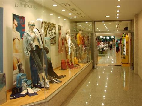 Tienda de ropa con entrada y pasillos amplios, mostrando un cartel de accesibilidad.