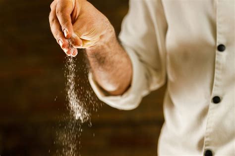 Foto temática de una persona esparciendo sal en un plato
