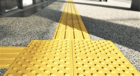 Ejemplo de baldosa podotáctil con botones en un cruce peatonal.