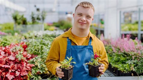 Foto de una persona con discapacidad trabajando en un centro de jardinería, simbolizando la inclusión laboral.