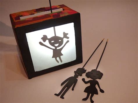 Niños haciendo un teatro de sombras, con un foco en la creatividad y la expresión.