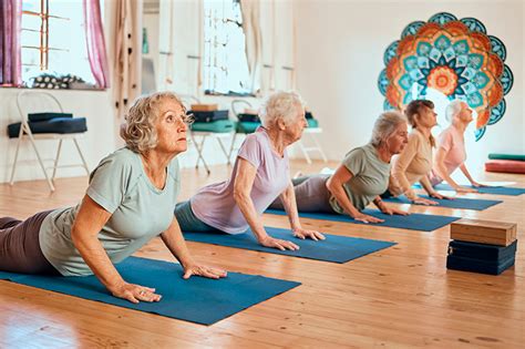 Foto de adultos mayores practicando yoga suave en un espacio luminoso