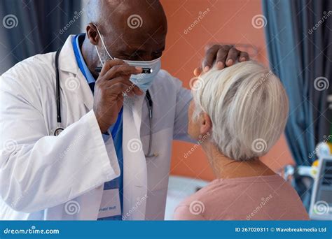 Médico especialista examinando el ojo de un paciente mayor