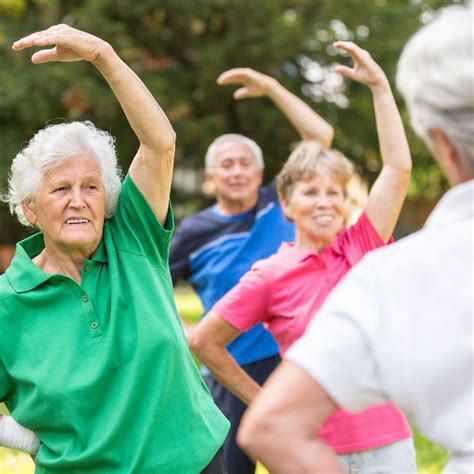 Grupo de adultos mayores realizando ejercicios de gimnasia suave en un entorno social