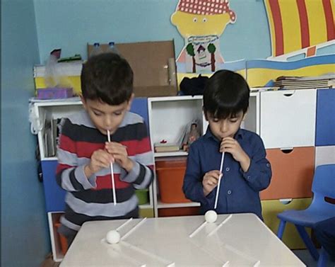 Niño realizando un ejercicio de soplo con una pajita.