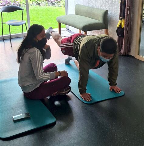 Fisioterapeuta experto revisando parámetros de dosificación de ejercicio con un paciente geriátrico