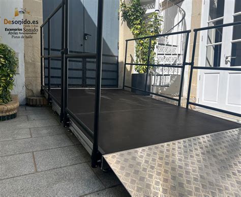 Foto de una rampa de acceso para personas con movilidad reducida con barandilla.