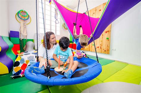 Terapeuta ocupacional trabajando con un niño en cama en un entorno domiciliario