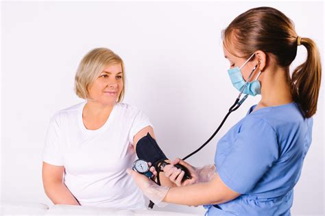 Enfermera realizando control de signos vitales a paciente en domicilio