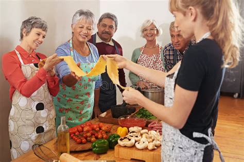Adultos mayores en un taller de cocina preparando una receta